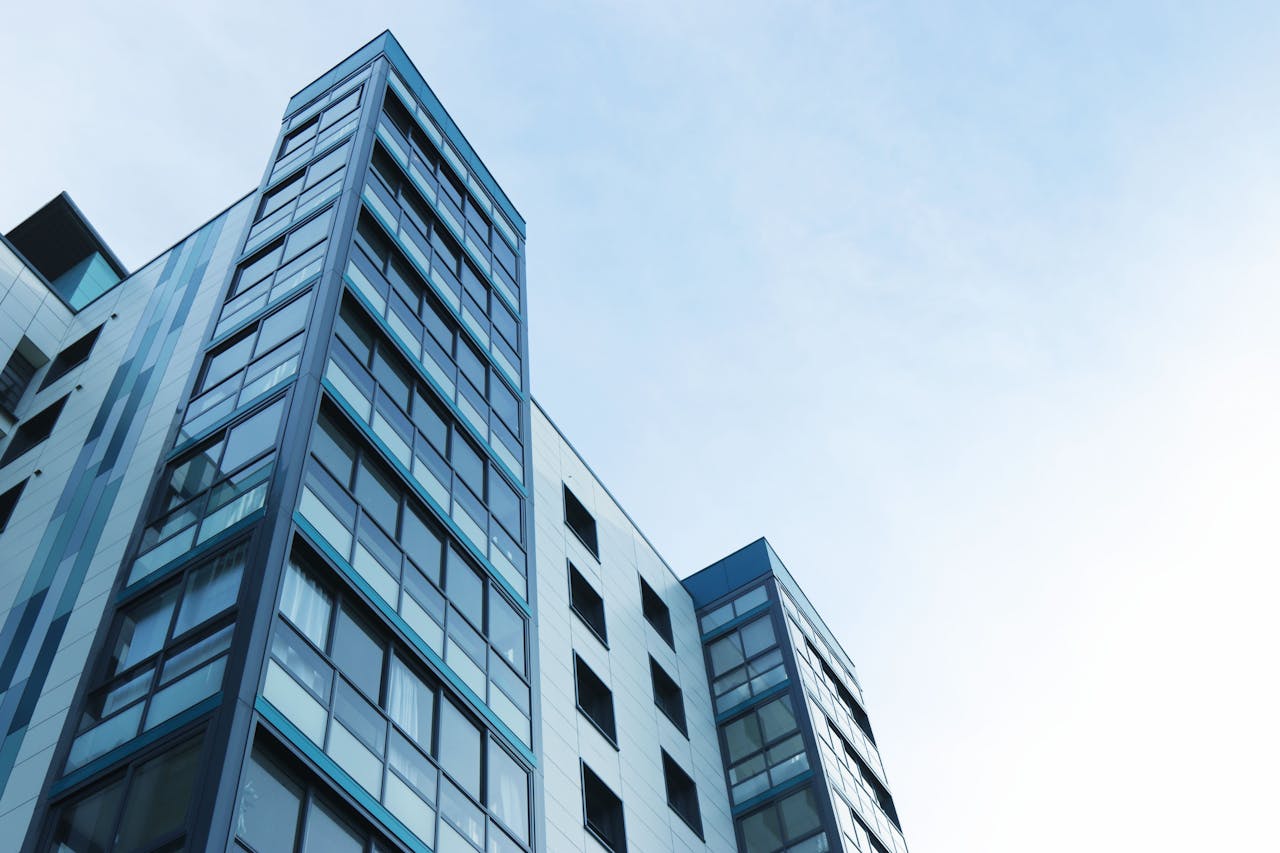 Services Low-angle view of a modern glass skyscraper against a clear sky in Poole, UK.